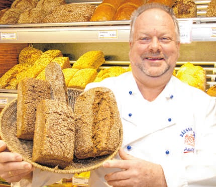 Bäckermeister Heinz Hintelmann mit seinem Lieblingsbrot, dem hellen Vollkorn. Da stecken viele wertvolle Nährstoffe drin! Foto: Löbenbrück