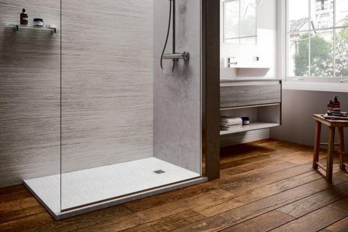 Zahllose Dekore sind möglich bei sehr flachen Duschflächen. Hier in schlichtem „Carraweiß“ und mit Betonung der Holzdielen, Foto: VDS/deal Standard