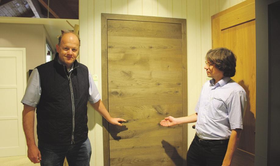 Geschäftsführer Uwe Wulff (l.) und Fachverkäufer Helmar Schröder stehen vor einer Wohnungstür aus hochwertigem Eichenholz Foto: jae