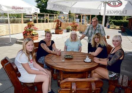 Günther und Anita Mehrens (Mitte) freuen sich, dass nach umfangreichen Renovierungen der Hotelzimmer, des Saals und des Restaurants jetzt auch die Terrasse am Landhaus Mehrens in Brande-Hörnerkirchen fertiggestellt ist Foto: Klein