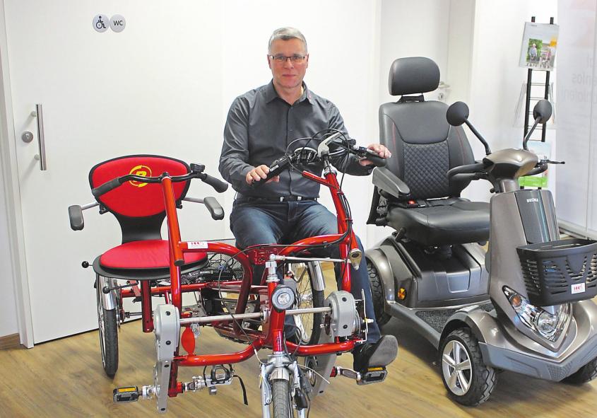 Geschäftsführer Ralf Hartz mit einer Auswahl möglicher Fahrzeuge – vom Dreirad bis zum Elektromobil. Foto: as