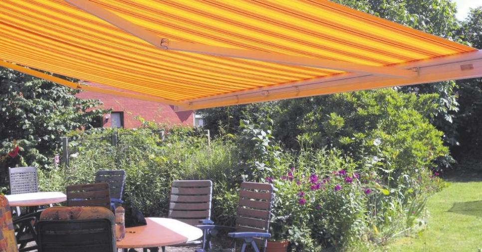 Eine Markise beschattet den Sitzplatz auf der Terrasse und bietet Schutz vor gefährlichen UV-Strahlen