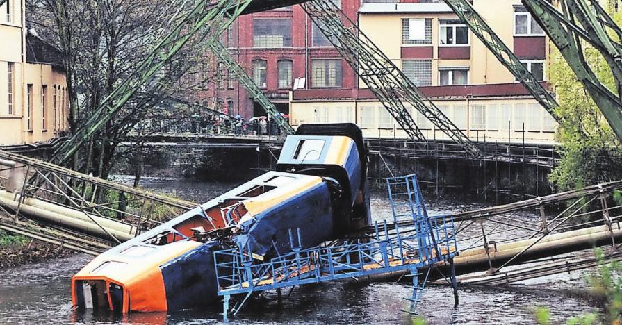 Dieses Bild machte ganz Deutschland auf Wuppertal aufmerksam: Nachdem Bauarbeiter während des Umbaus eine Kralle vergessen hatten, stürzte die Schwebebahn 1999 nahe des Robert-Daum-Platzes in die Wupper. Fünf Menschen starben, weitere wurden verletzt. Archiv-Foto: Kurt Keil Dieses Bild machte ganz Deutschland auf Wuppertal aufmerksam: Nachdem Bauarbeiter während des Umbaus eine Kralle vergessen hatten, stürzte die Schwebebahn 1999 nahe des Robert-Daum-Platzes in die Wupper. Fünf Menschen starben, weitere wurden verletzt. Archiv-Foto: Kurt Keil