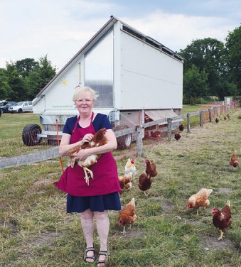 Maren Pein räsentiert das neue Hühnermobil des Almthofes Foto: Kuno Klein