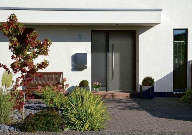 Elegante und klar gezeichnete Eingangstür passend zum schön angelegten Vorgarten. Foto: Rodenberg/Aldra Fenster und Türen