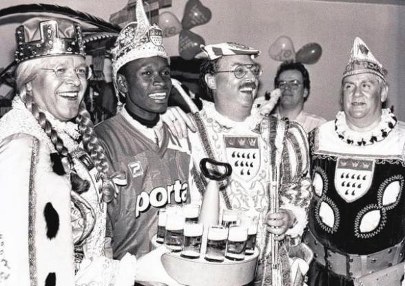 ...Oder wie der langjährige Co-Trainer der 1. Mannschaft, Dieter Epstein, und der Sohn des Busunternehmers, Jürgen Weinzierl, zum Flughafen fuhren, um Charles Akonnor, der erstmalig aus Ghana nach Europa gekommen war, abzuholen und auf Lörings „Befehl“ gleich in den „Schmitze Lang“ auf die Severinsstraße brachten. Charles landete so an Weiberfastnacht quasi im Epizentrum des kölschen Frohsinns und sang mit Bömmel, Hartmut und Prinz Wicky Junggeburth „Eimol Prinz zo sin“. Foto: Archiv ...Oder wie der langjährige Co-Trainer der 1. Mannschaft, Dieter Epstein, und der Sohn des Busunternehmers, Jürgen Weinzierl, zum Flughafen fuhren, um Charles Akonnor, der erstmalig aus Ghana nach Europa gekommen war, abzuholen und auf Lörings „Befehl“ gleich in den „Schmitze Lang“ auf die Severinsstraße brachten. Charles landete so an Weiberfastnacht quasi im Epizentrum des kölschen Frohsinns und sang mit Bömmel, Hartmut und Prinz Wicky Junggeburth „Eimol Prinz zo sin“. Foto: Archiv
