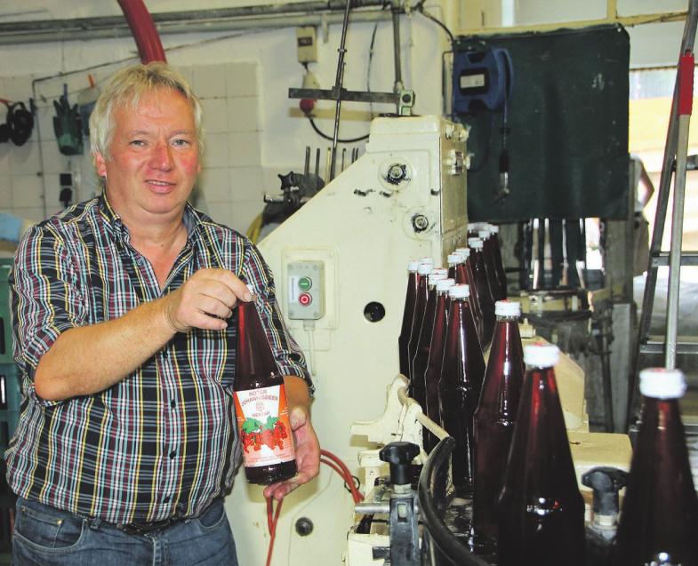 Inhaber Martin Schmidt an der Anlage, in der gerade roter Johannisbeer- Nektar in Flaschen abgefüllt wird Foto: cs