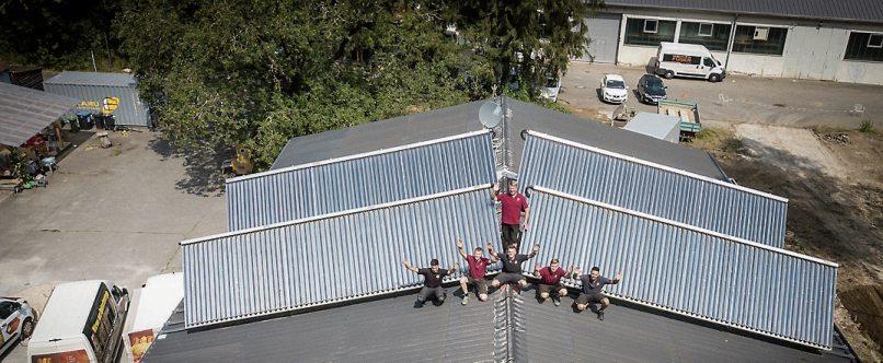 Das Team von Ro-Bi TEC auf einem Solarhaus.
