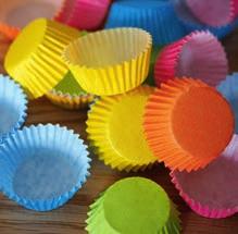 Mit Muffin-Papierförmchen Kinderkleider vor Kleckerflecken schützen: Einfach von unten über den Eisstiel schieben