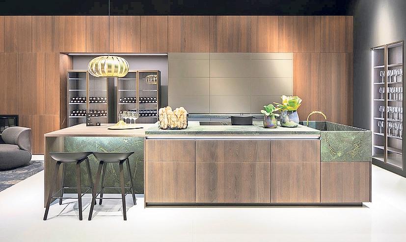 Hochwertiges Eichenholz, echter graugrüner Granit beim Inselblock und der Spüle, filigrane Vitrinen mit schmalen Metallrahmen und LED-Lichtprofilen sowie flächenbündig in die Wand integrierte Hochschränke, geben in dieser luxeriösen Premium-Wohnküche den Ton an. Foto: AMK Hochwertiges Eichenholz, echter graugrüner Granit beim Inselblock und der Spüle, filigrane Vitrinen mit schmalen Metallrahmen und LED-Lichtprofilen sowie flächenbündig in die Wand integrierte Hochschränke, geben in dieser luxeriösen Premium-Wohnküche den Ton an. Foto: AMK