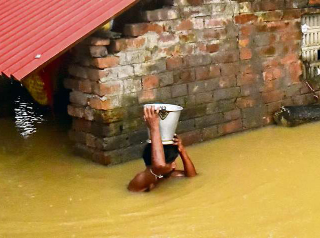 August 2021. Ein Mann vor seinem überfluteten Haus im indischen Udaynarayanpur. Die Ärmsten der Welt tragen am wenigstens zur Erderhitzung bei.