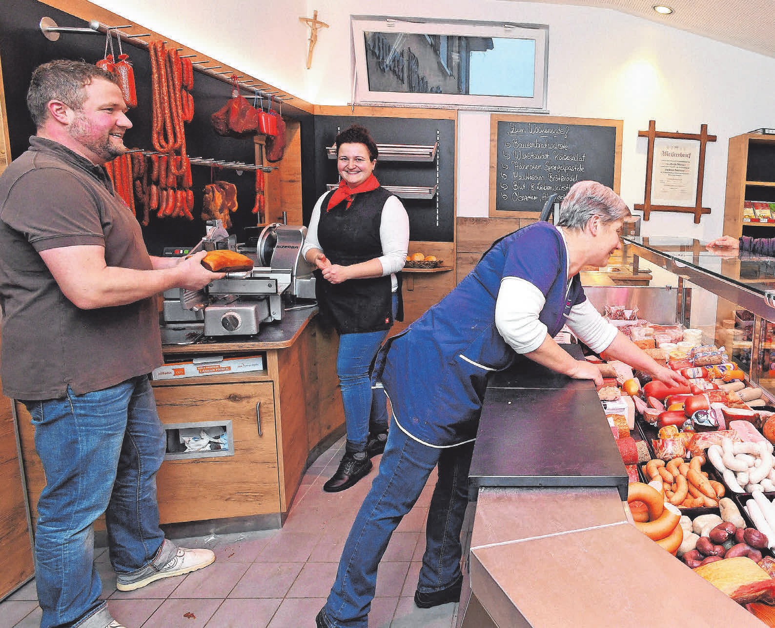 Markus Maier, seine Schwester Gabi Maier (Fleischereifachverkäuferin und Verkaufsleiterin im Fleischerhandwerk) und Mutter Josefa Maier (von links) im neuen Metzgerei-Verkaufsraum mit großer Glastheke. FOTO: BERND BAUR