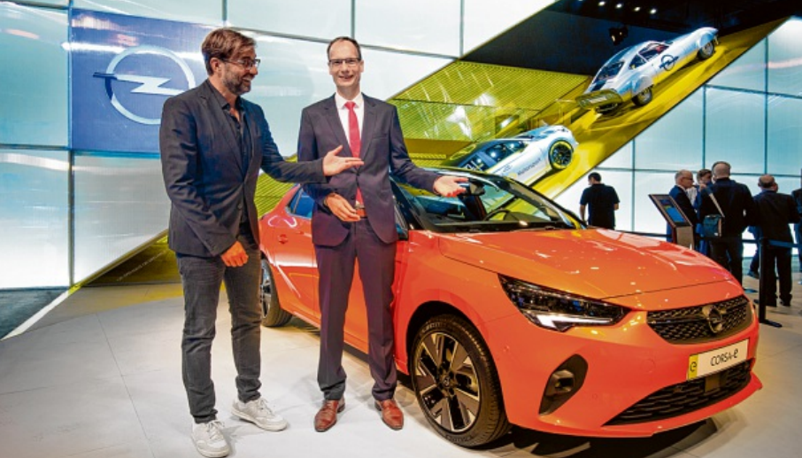 Prominenter Gast auf der IAA: Meistertrainer Jürgen Klopp (links) ließ sich von Opel-Chef Michael Lohscheller den Elektro-Corsa zeigen. FOTO: HERSTELLER