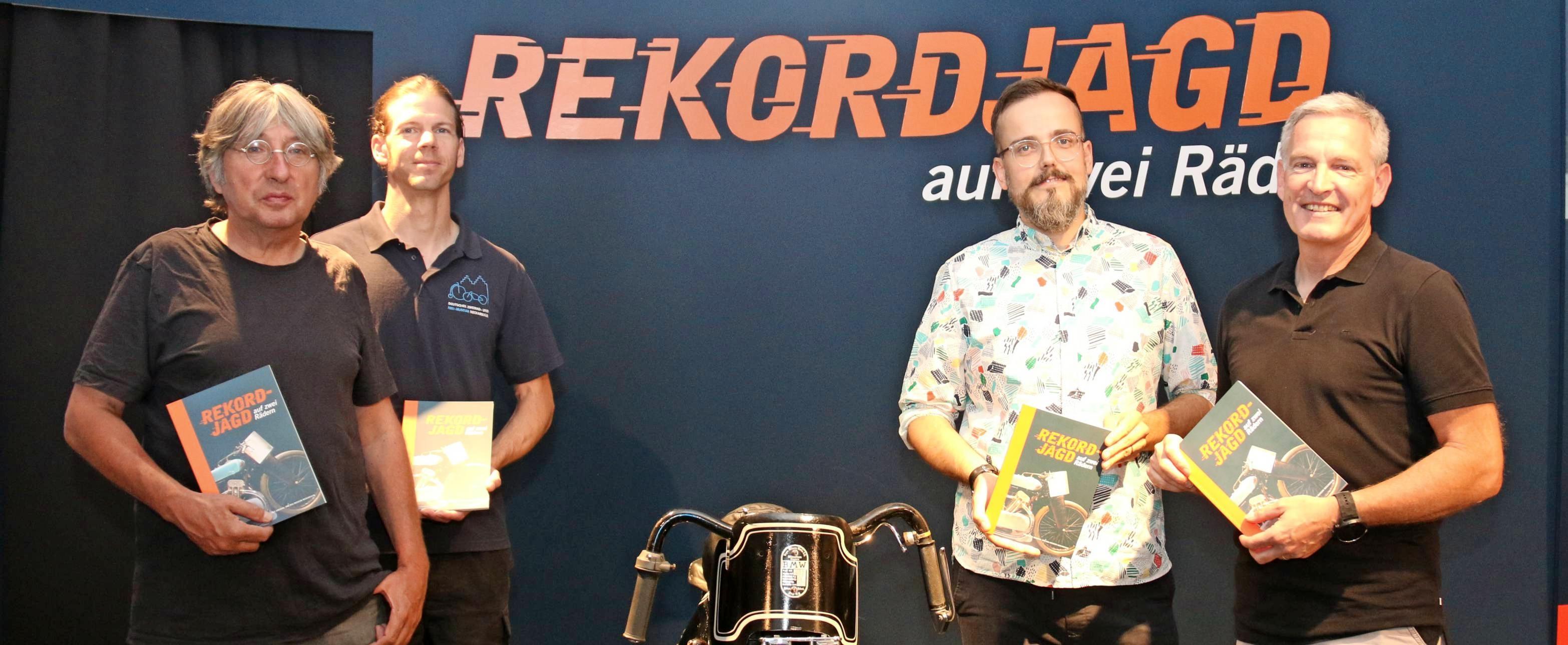 Zur Ausstellung „Rekordjagd auf zwei Rädern“ im Zweiradmuseum ist ein Katalog erschienen: (von links) Autor Manfred Ratzinger, Museumsmitarbeiter Sven Heimberger, Grafiker Heiko Hagner und Fotograf Jürgen Häffner. Foto: snp Zur Ausstellung „Rekordjagd auf zwei Rädern“ im Zweiradmuseum ist ein Katalog erschienen: (von links) Autor Manfred Ratzinger, Museumsmitarbeiter Sven Heimberger, Grafiker Heiko Hagner und Fotograf Jürgen Häffner. Foto: snp