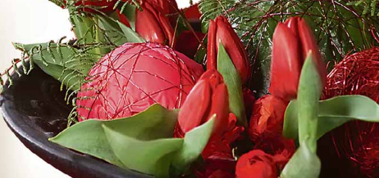 Durch Deko-Elemente wie Kugeln gibt man einem Tulpengesteck den weihnachtlichen Anstrich. Foto: TulpenZeit Durch Deko-Elemente wie Kugeln gibt man einem Tulpengesteck den weihnachtlichen Anstrich. Foto: TulpenZeit