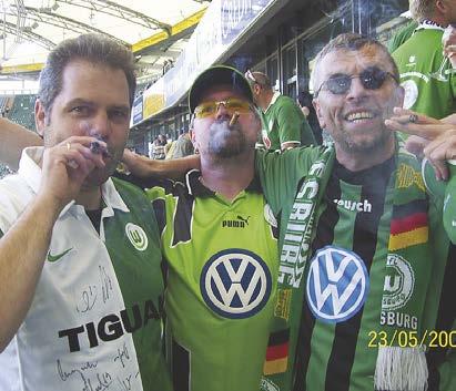 Olaf Göttling aus Wolfsburg zeigt, wie er die „Meisterzigarre“ mit seinen Freunden Frank und Jürgen im Stadion genießt.