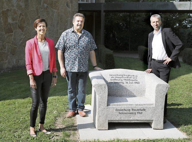 Der Tübinger Bergfriedhof „thront“ seit 1950 als Hauptfriedhof auf dem Galgenberg. Aus diesem Grund wurde anlässlich des Jubiläums Granitsessel mit geschichtlichen Informationen zum Bergfriedhof bei der Großen Trauerhalle aufgestellt – zur Freude von Miriam Ibrahimovic, Leiterin der kommunalen Servicebetriebe Tübingen, Bernd Walter, Bereichsleiter Friedhofswesen, sowie Oberbürgermeister Boris Palmer. Bild: Anne Faden