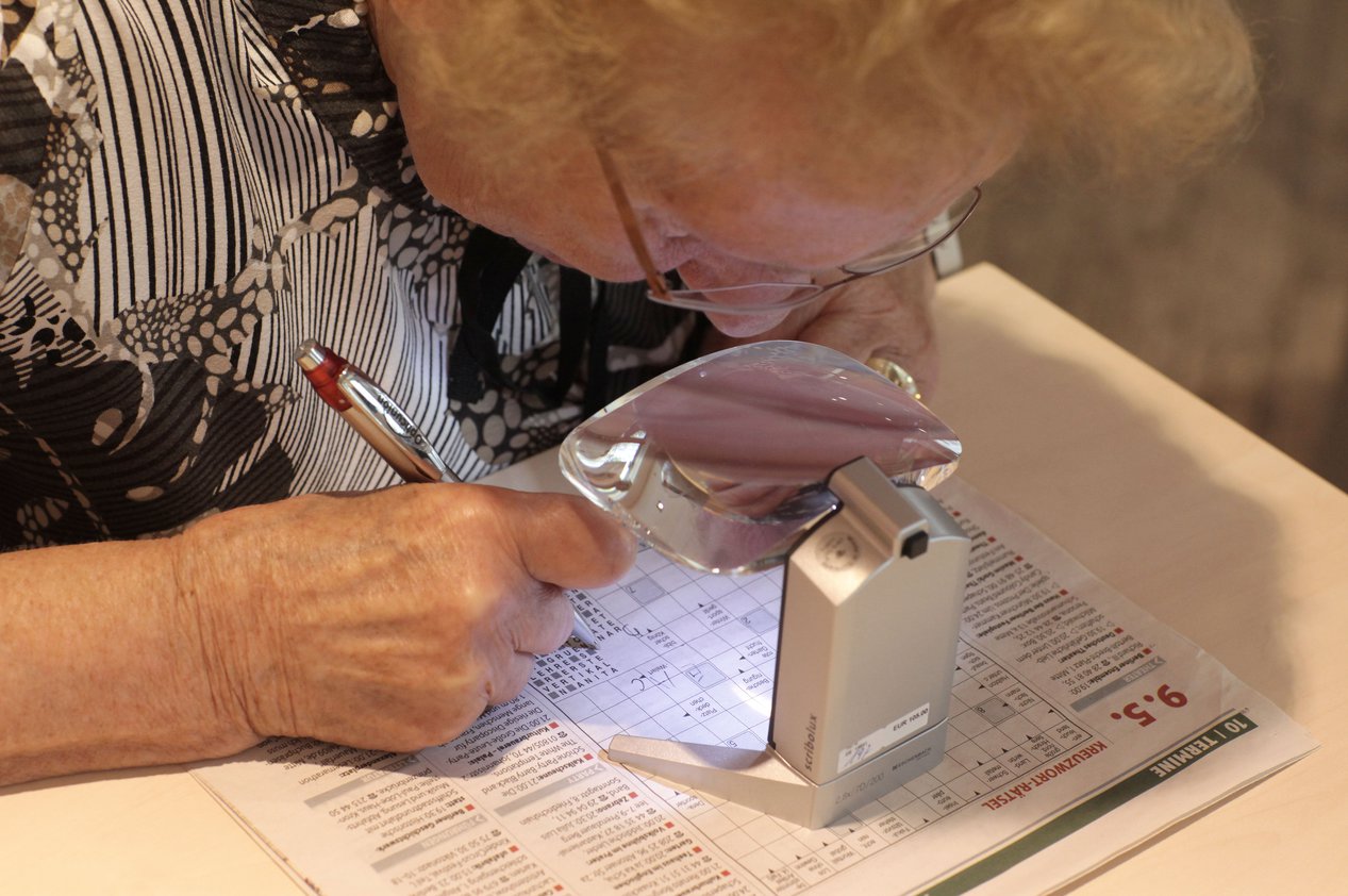 Eine sehbehinderte Frau löst Kreuzworträtsel. Eine Licht-Lupe erleichtert ihr dabei das Erkennen der Schrift. FOTO: DBSV/A. FRIESE Eine sehbehinderte Frau löst Kreuzworträtsel. Eine Licht-Lupe erleichtert ihr dabei das Erkennen der Schrift. FOTO: DBSV/A. FRIESE