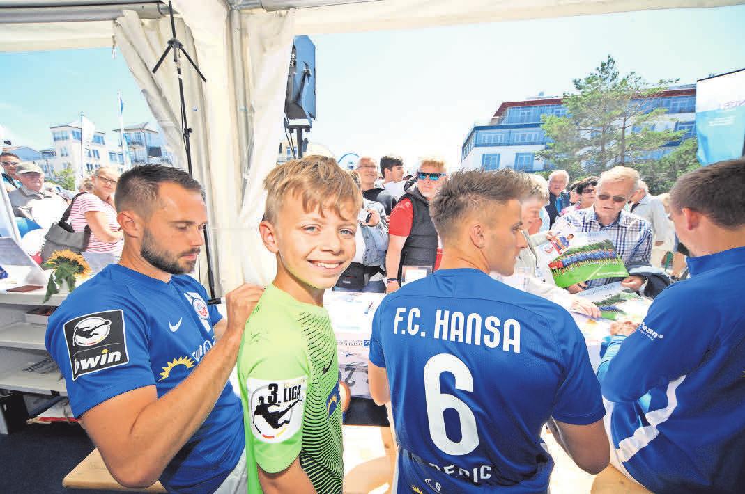 Abwechslung: Bei der Warnemünder Woche waren Pascal Breier, Mirnes Pepic und Frederik Lach (v.l.) zu Gast beim Sportbuzzer-Aktionstag der OZ. John (9) aus Rostock ließ sich ein Trikot signieren. Foto: Ove Arscholl Abwechslung: Bei der Warnemünder Woche waren Pascal Breier, Mirnes Pepic und Frederik Lach (v.l.) zu Gast beim Sportbuzzer-Aktionstag der OZ. John (9) aus Rostock ließ sich ein Trikot signieren. Foto: Ove Arscholl