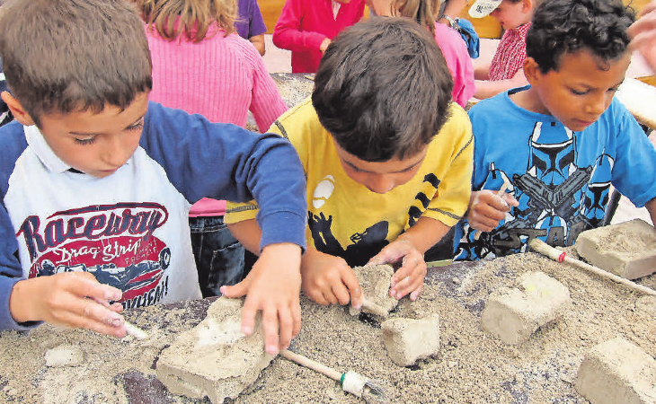 Mit Begeisterung sind die Kids beim Bergen eines Fossils oder Skeletts dabei. Mit Begeisterung sind die Kids beim Bergen eines Fossils oder Skeletts dabei.