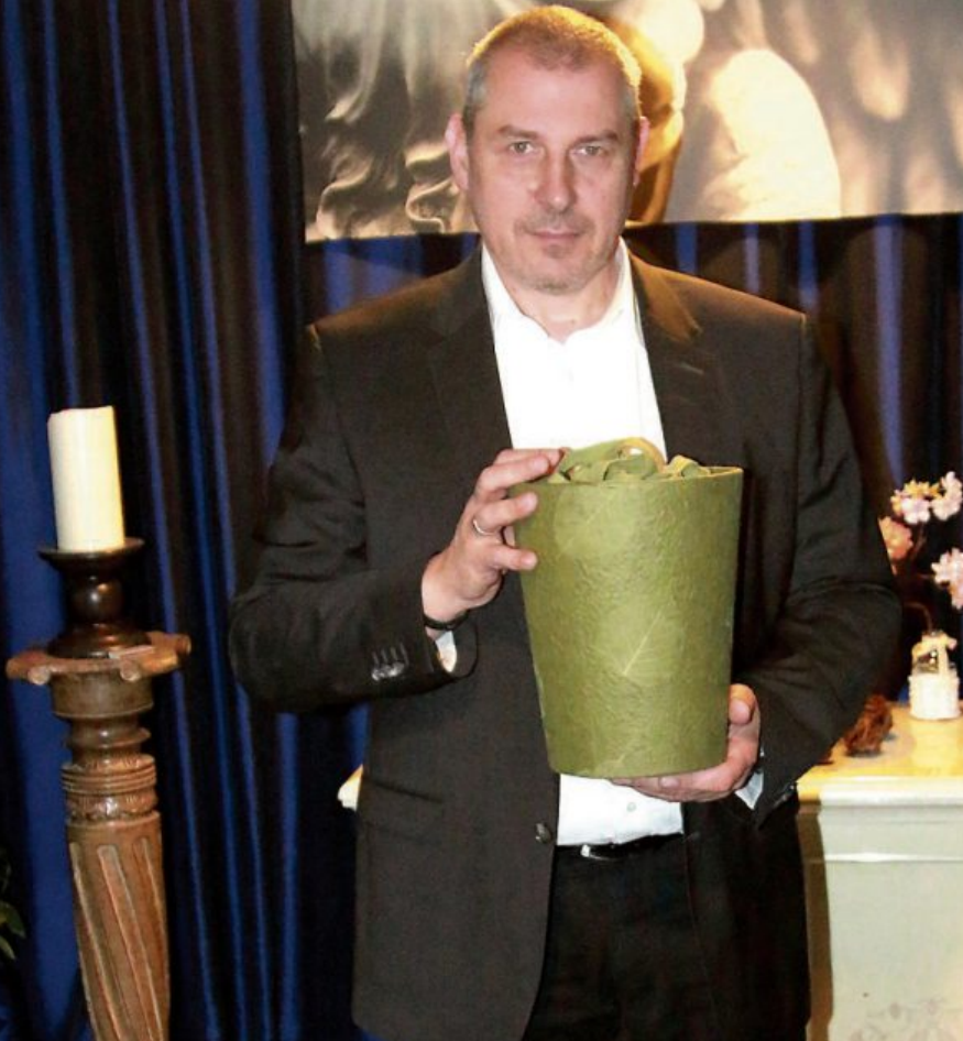Roberto Seifert mit einer Naturstoffurne aus handgeschöpftem Loktapapier. Bild: Stefan Zibulla