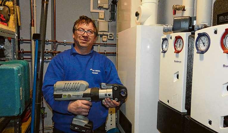 Marco Berndt-Koch zeigt eine Profi-Pressmaschine, mit der Wasserleitungen verbunden werden Foto: Rutke 