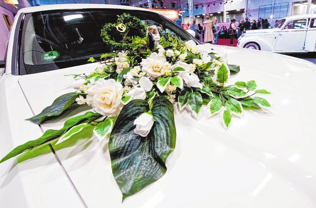 Schöne Blumen auf der Motorhaube sind ein typischer Schmuck fürs Hochzeitsauto – sie dürfen dem Fahrer aber nicht die Sicht nehmen. FOTO: ANDREA WARNECKE, TMN Schöne Blumen auf der Motorhaube sind ein typischer Schmuck fürs Hochzeitsauto – sie dürfen dem Fahrer aber nicht die Sicht nehmen. FOTO: ANDREA WARNECKE, TMN