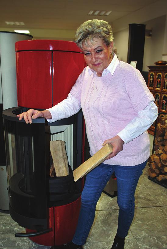 Ofenbauerin Gudrun Julian heizt dem Ofen „Romotop Soria 01“ kräftig ein, der mit einem schönen Farb-Design auffällt