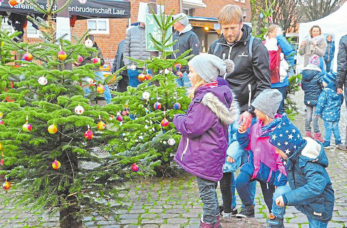 Schon die jüngsten Laerer beteiligen sich an ihrem Weihnachtsmarkt: Sie schmücken die Tannenbäume im Ortskern. Foto: Rainer Nix Schon die jüngsten Laerer beteiligen sich an ihrem Weihnachtsmarkt: Sie schmücken die Tannenbäume im Ortskern. Foto: Rainer Nix