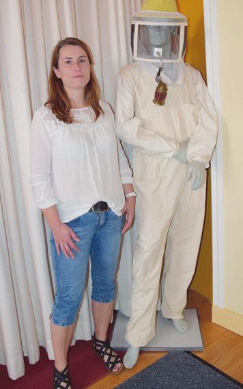 Katja Prüssing neben einer Figur mit Schutzbekleidung für Imker