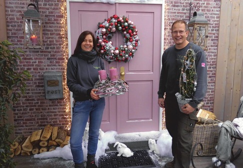 Auf den üppig bestückten Türkranz, der perfekt zur Tür in pudrigem Rosa passt, sind Florian Neumann und seine Floristin Claudia Mahncke besonders stolz Foto: Skibbe