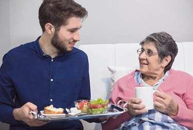 Freiwillige in der Altenpflege helfen älteren Menschen z. B. beim Essen und Trinken