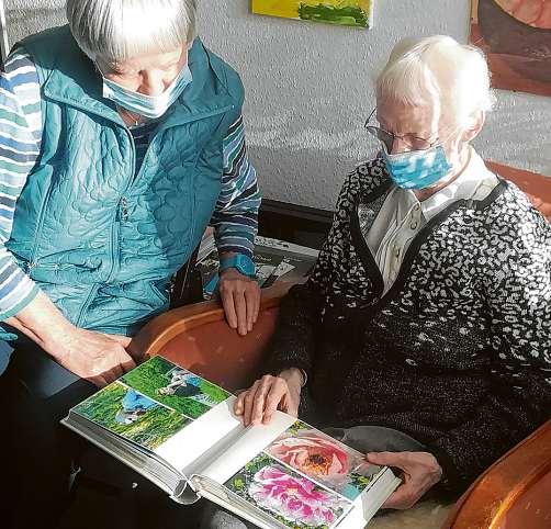 Gemeinsam in einem Fotoalbum zu blättern ruft Erinnerungen wach und bietet Gesprächsstoff. Foto: Bezirks-Seniorenbeirat Wandsbek