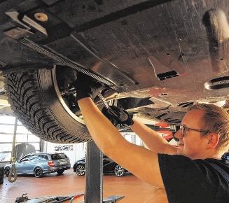Mitarbeiter Maximilian Hauch arbeitet in der Werkstatt an einem Kundenwagen. Mitarbeiter Maximilian Hauch arbeitet in der Werkstatt an einem Kundenwagen.